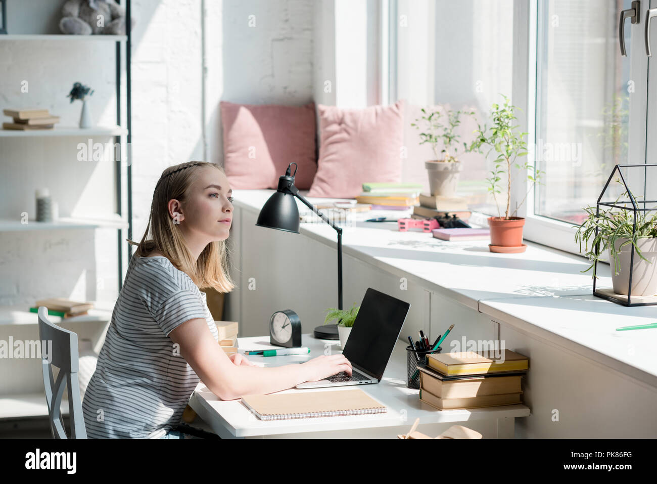 Thoughtful Teen Student Girl Sitting At Work Desk At Home Stock
