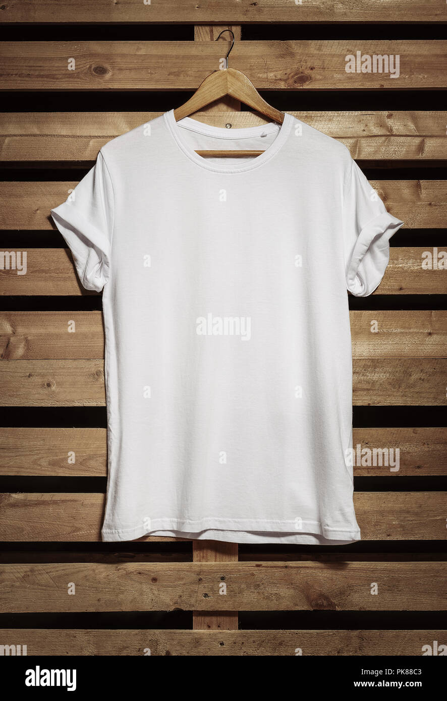 Blank white t-shirt hanging on the wooden background, with copy space Stock  Photo - Alamy