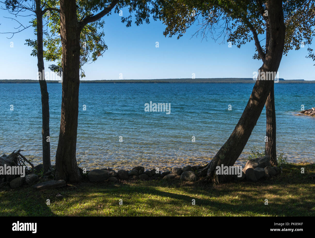 Lake Manitou shoreline landscape with cedar trees and rocks on ...