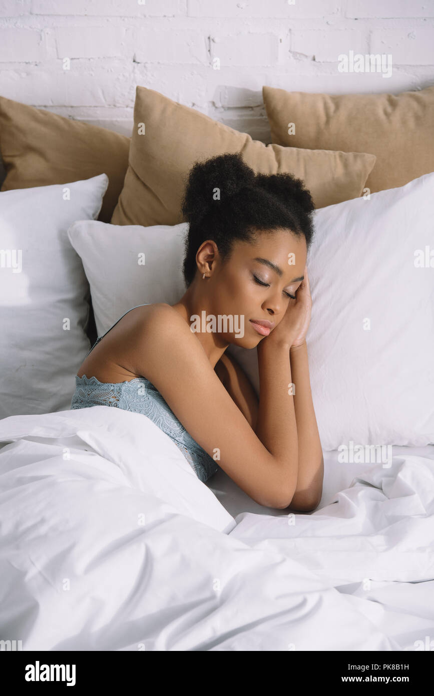 attractive african american girl sleeping on pillows in bed Stock Photo ...