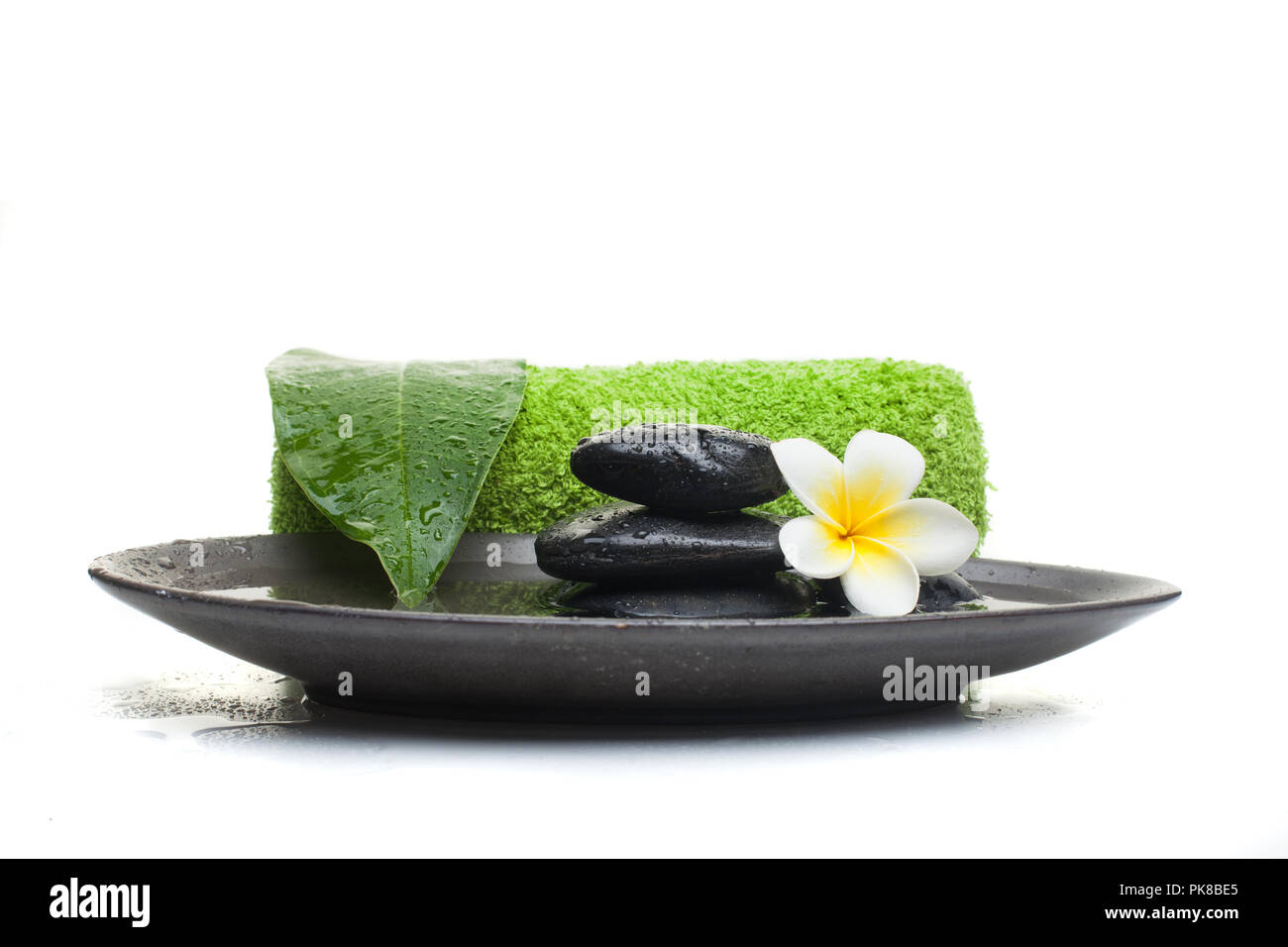 Spa Set with stones and towel and leaves on white background. Stock Photo