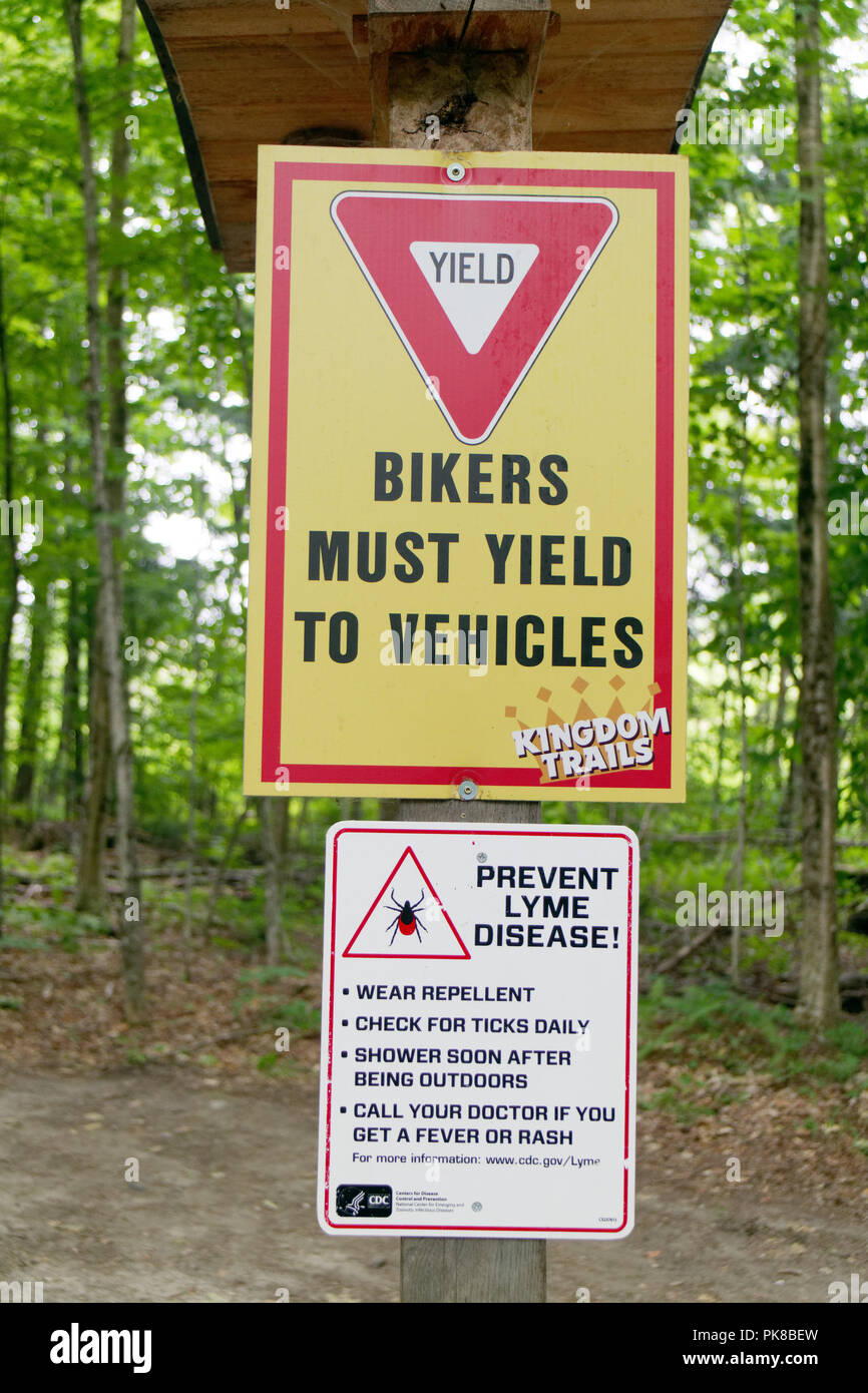 A sign in the woods at the Kingdom Trails mountain bike area warning of Lyme Disease from ticks Stock Photo