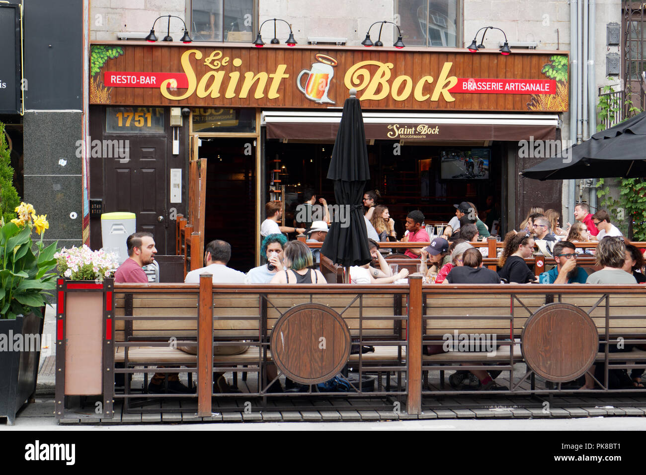 People sat on table outside the Saint Bock pub and microbrewery on Rue St Denis in Montreal Stock Photo