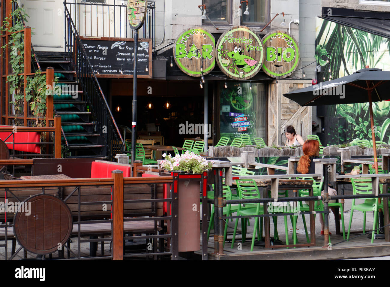 People sat on table outside the Green Panther organic pub restaurant on Rue St Denis in Montreal Stock Photo