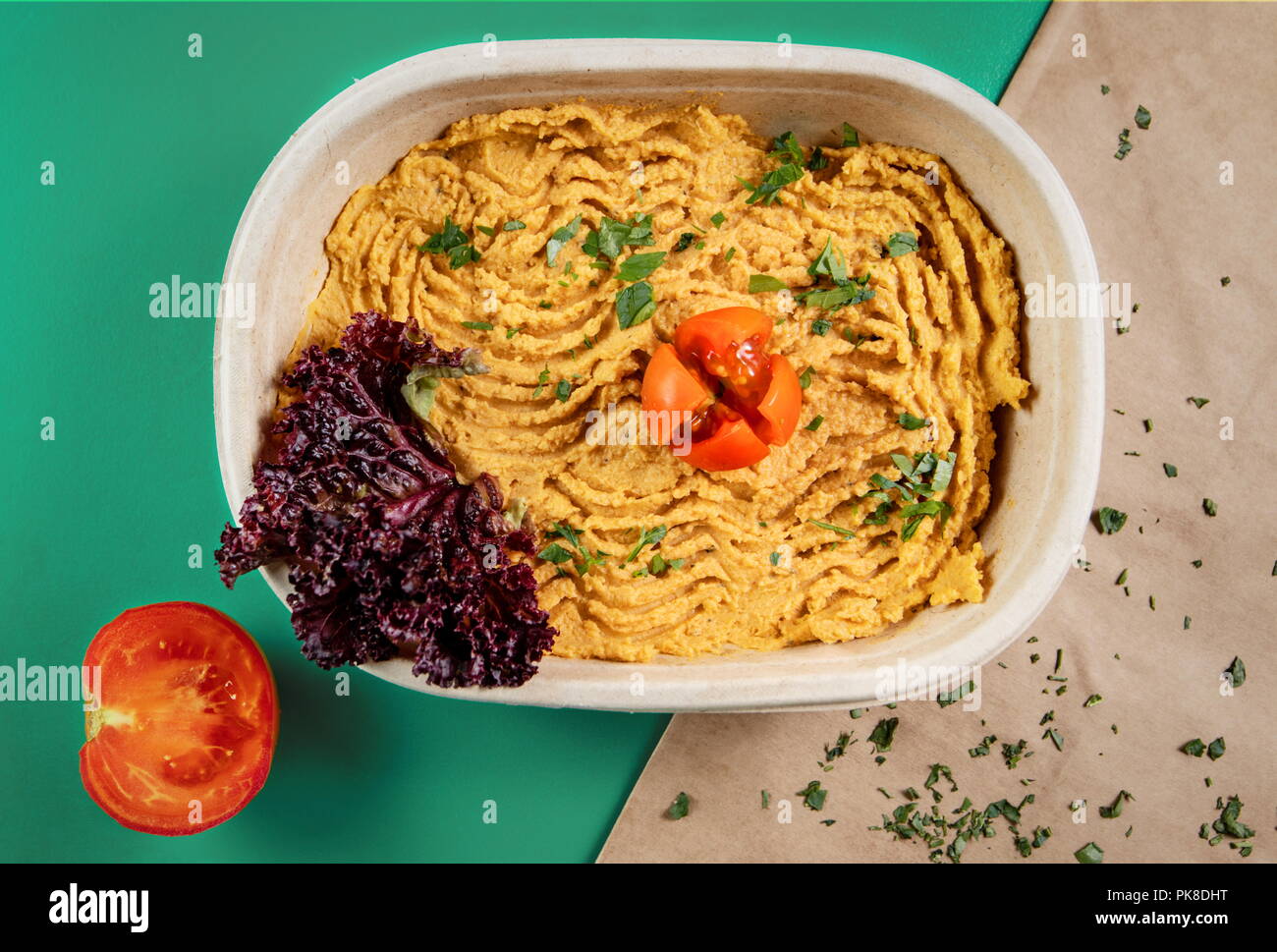 Hummus  recipe arranged in cardboard packaging, on green background and wrapping paper Stock Photo