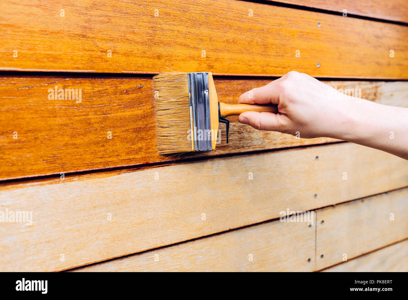Male hand painting wooden wall with a brush painting woodwork outside Stock Photo Alamy