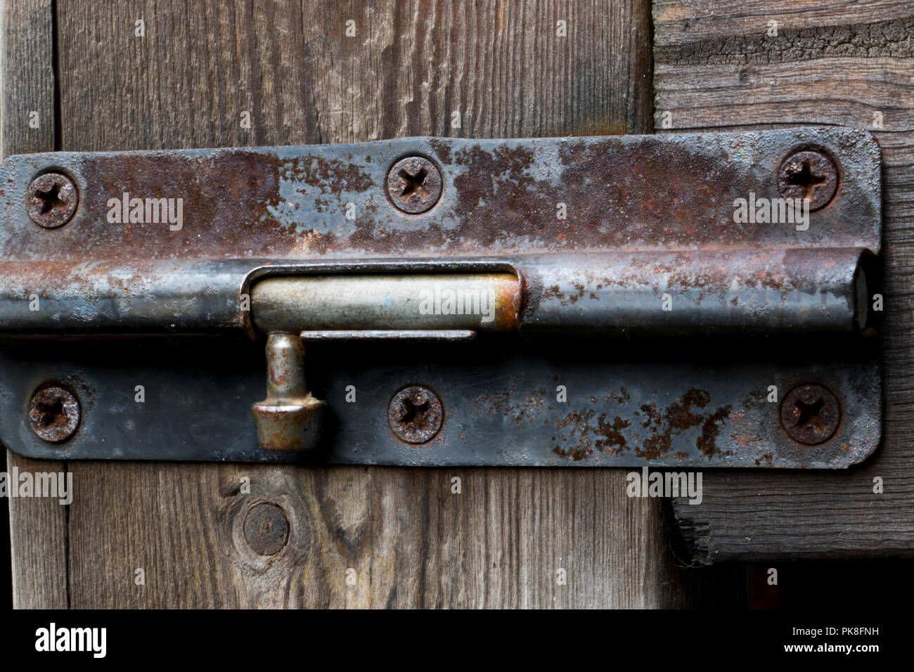 Old Rust Outdoor Bolt Lock On A Wooden Fence Stock Photo