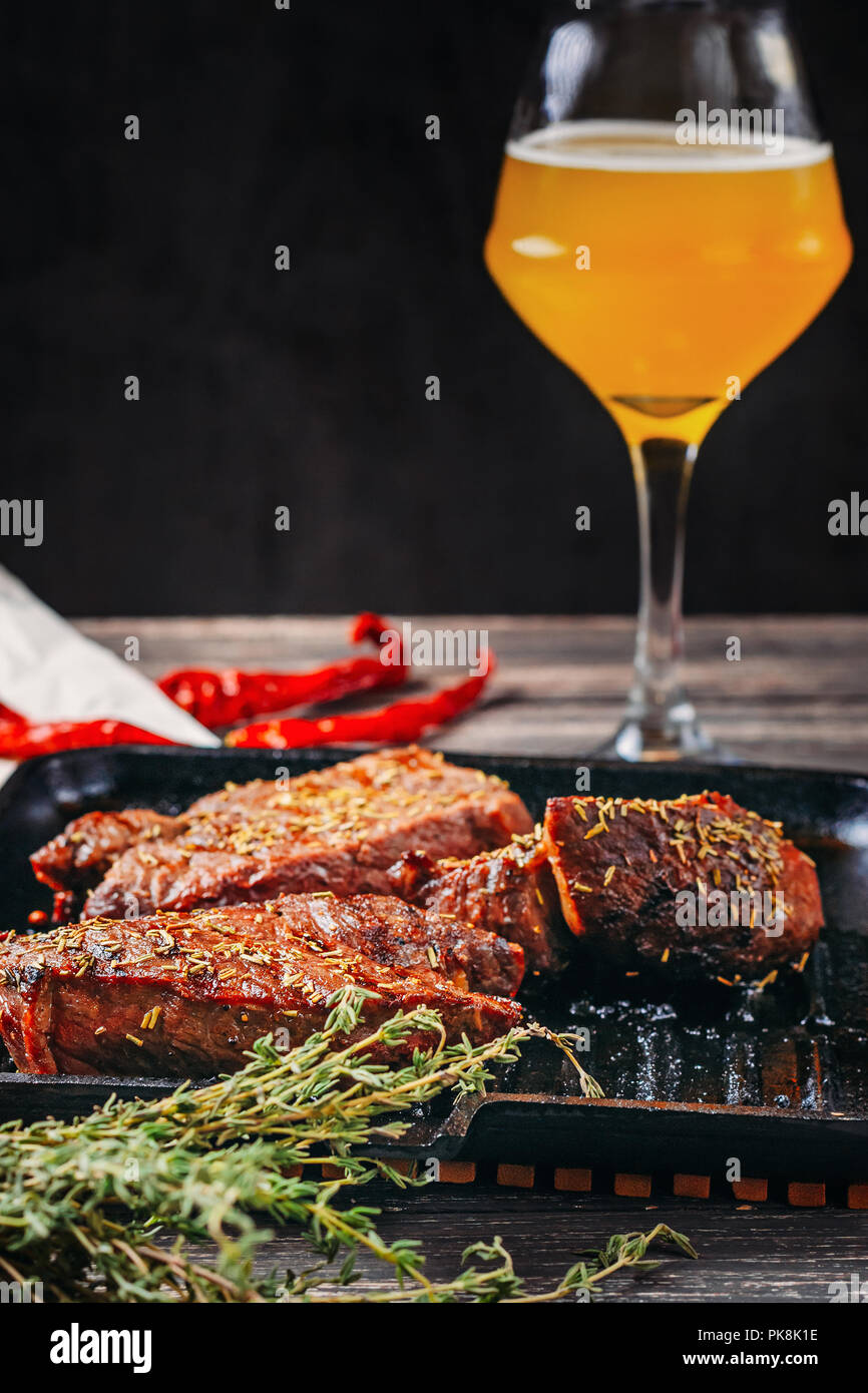 https://c8.alamy.com/comp/PK8K1E/fried-meat-steaks-in-frying-pan-and-a-glass-of-beer-close-up-PK8K1E.jpg