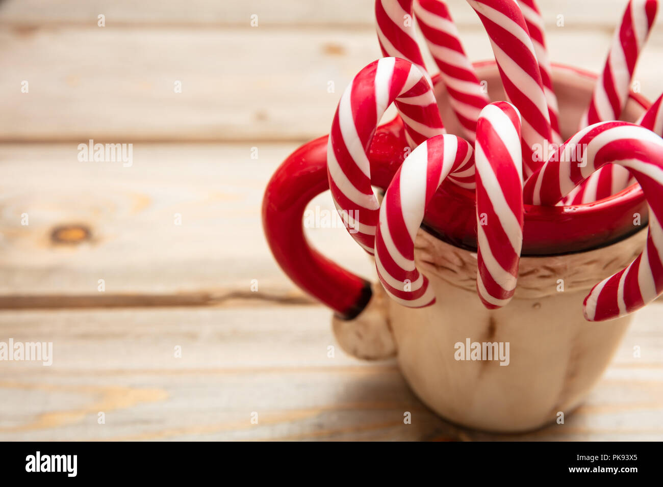 https://c8.alamy.com/comp/PK93X5/christmas-time-candy-canes-in-a-cup-wooden-background-copy-space-PK93X5.jpg