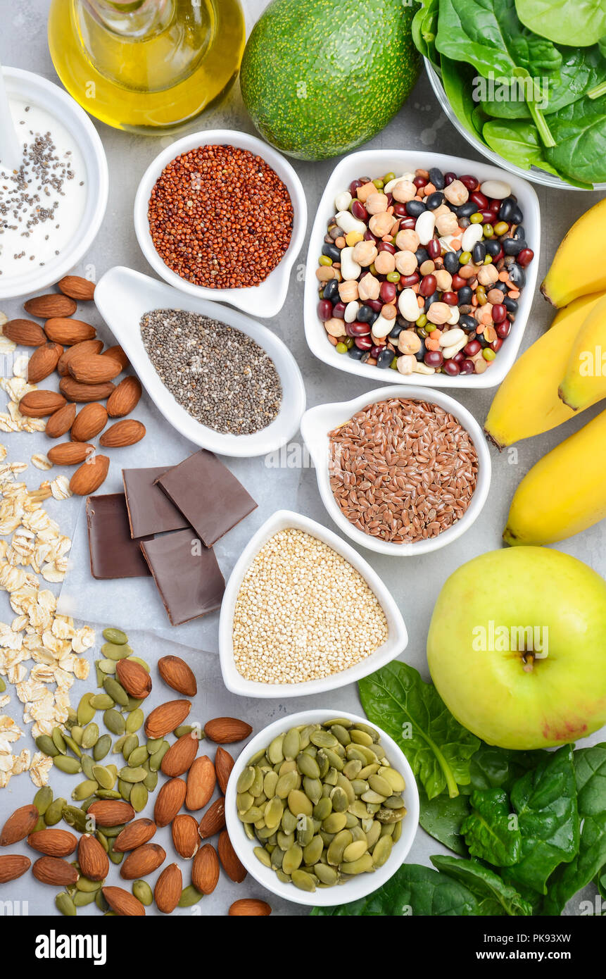 Healthy food nutrition dieting concept. Banana, chocolate, spinach, avocado, apple, quinoa, chia, flax seeds, yogurt, almond, beans, oat, pumpkin seed. Stock Photo