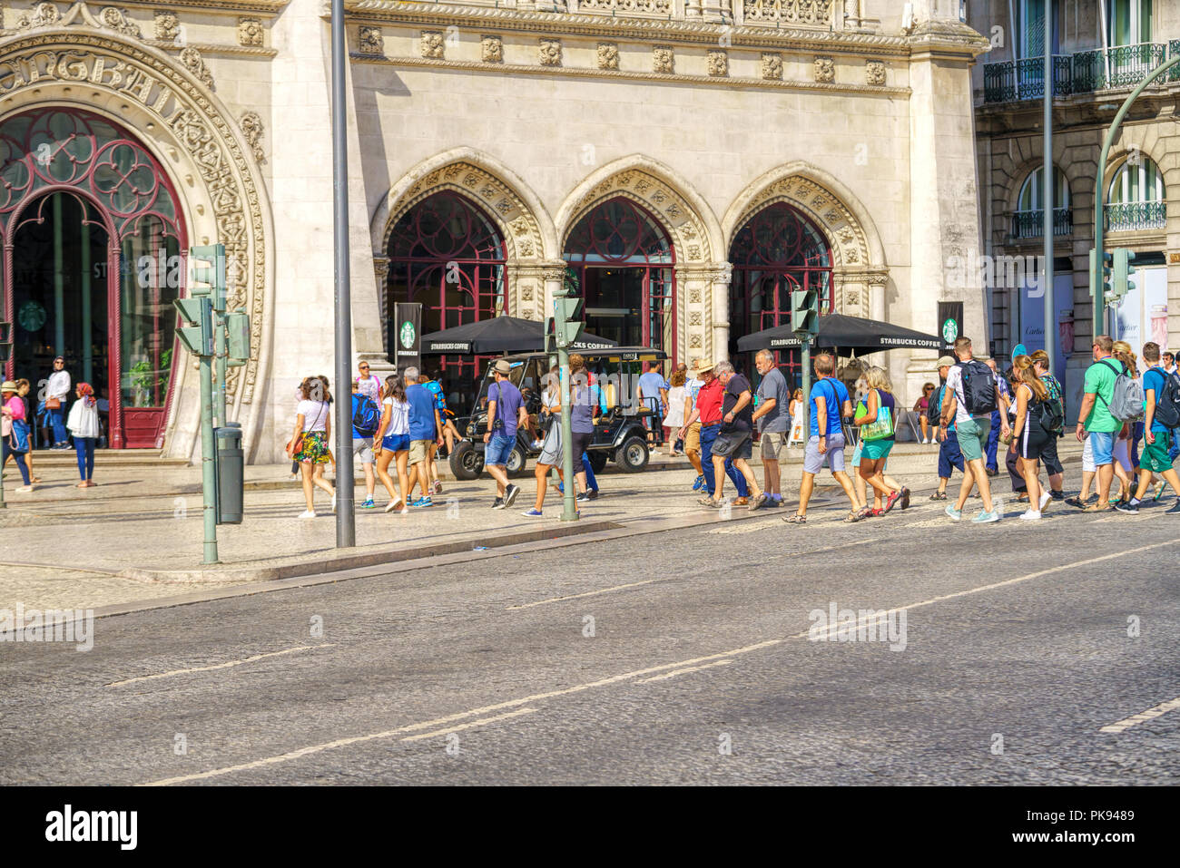 Entrance doors to Rossio Railway Station, People in front of the Neo-Manueline style facade of Rossio railway station in Lisbon Stock Photo