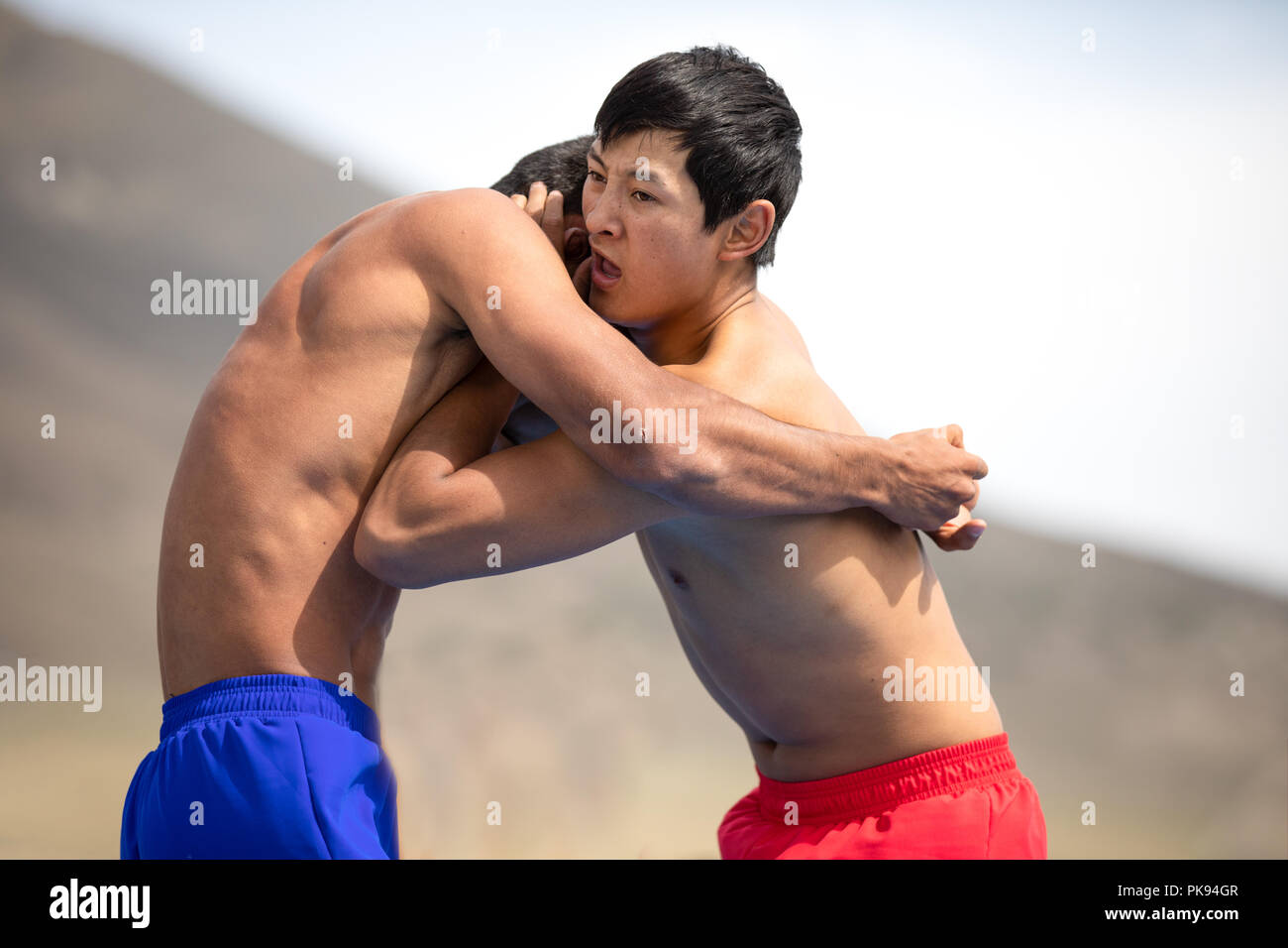 Lake Issyk-Kul, Kyrgyzstan - Sep 6, 2018: Close-up of wo young men wrestling outdoors during 2018 World Nomad Games. Stock Photo