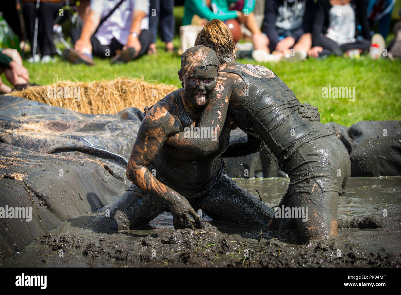 Two women mud wrestling at a mud fighting competition at The LowLand Games in Thorney Somerset Stock Photo