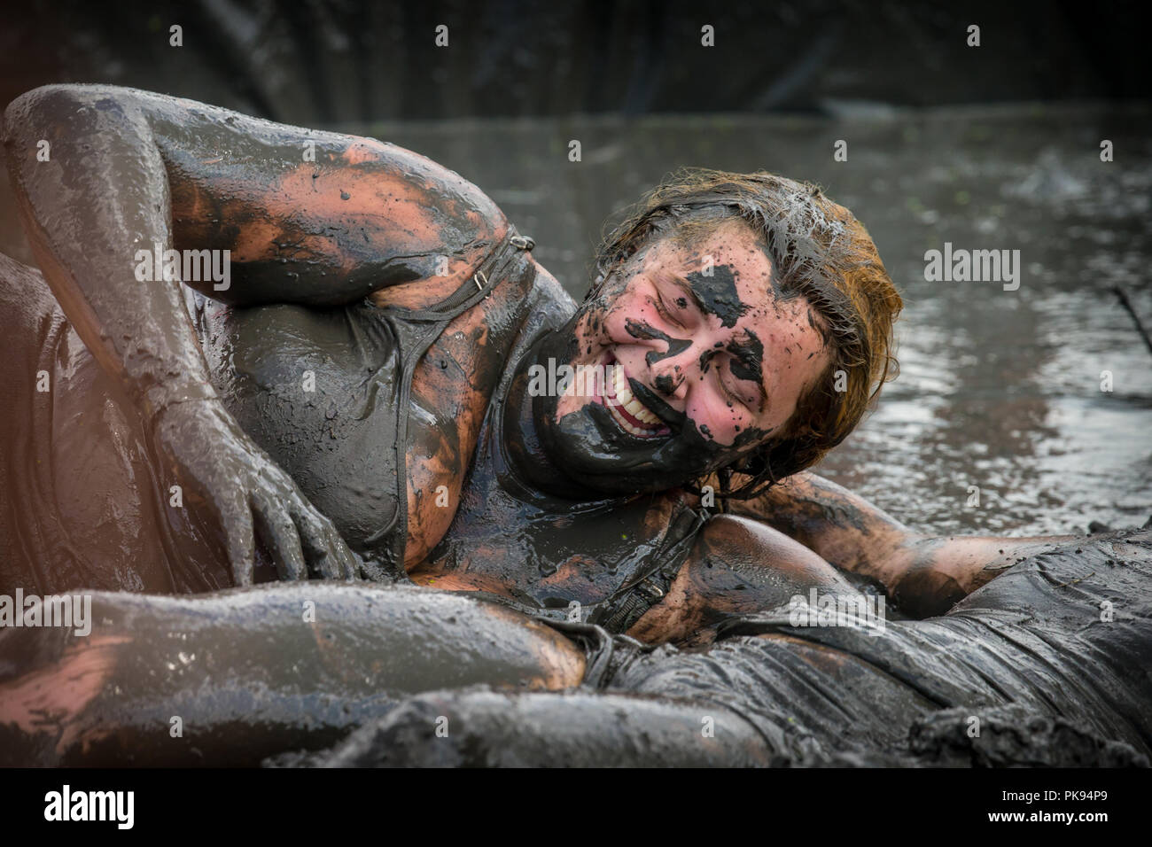 Two women mud wrestling at a mud fighting competition at The LowLand Games in Thorney Somerset Stock Photo