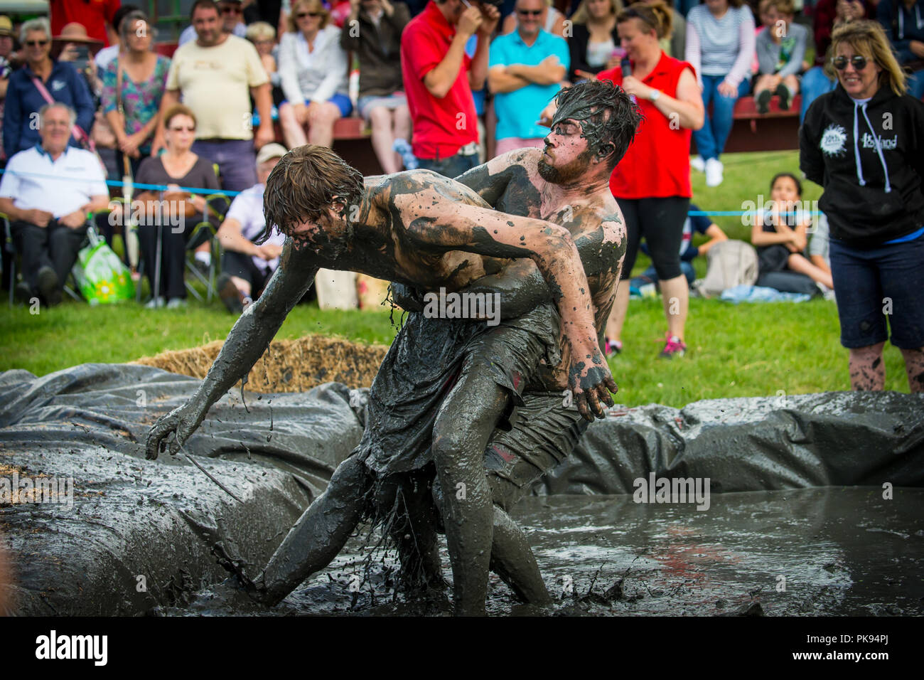 Two men mud wrestling at a mud fighting competition at The LowLand Games in Thorney Somerset Stock Photo