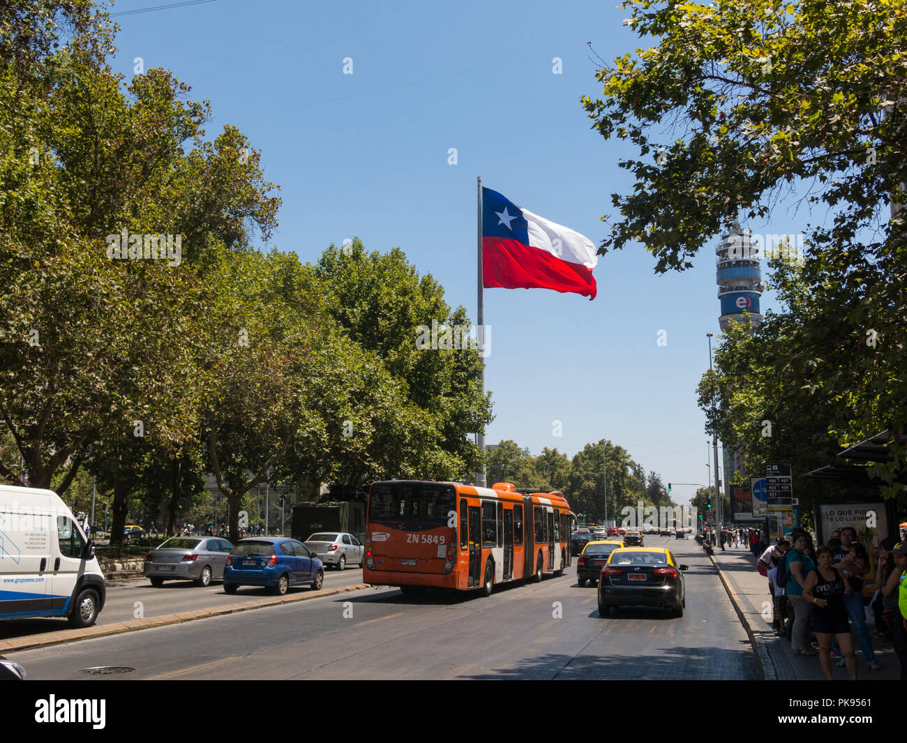 Intense traffic on Avenida La Alameda, the most important street in Santiago de Chile. In the background,, the flag of Citizenship Square Stock Photo