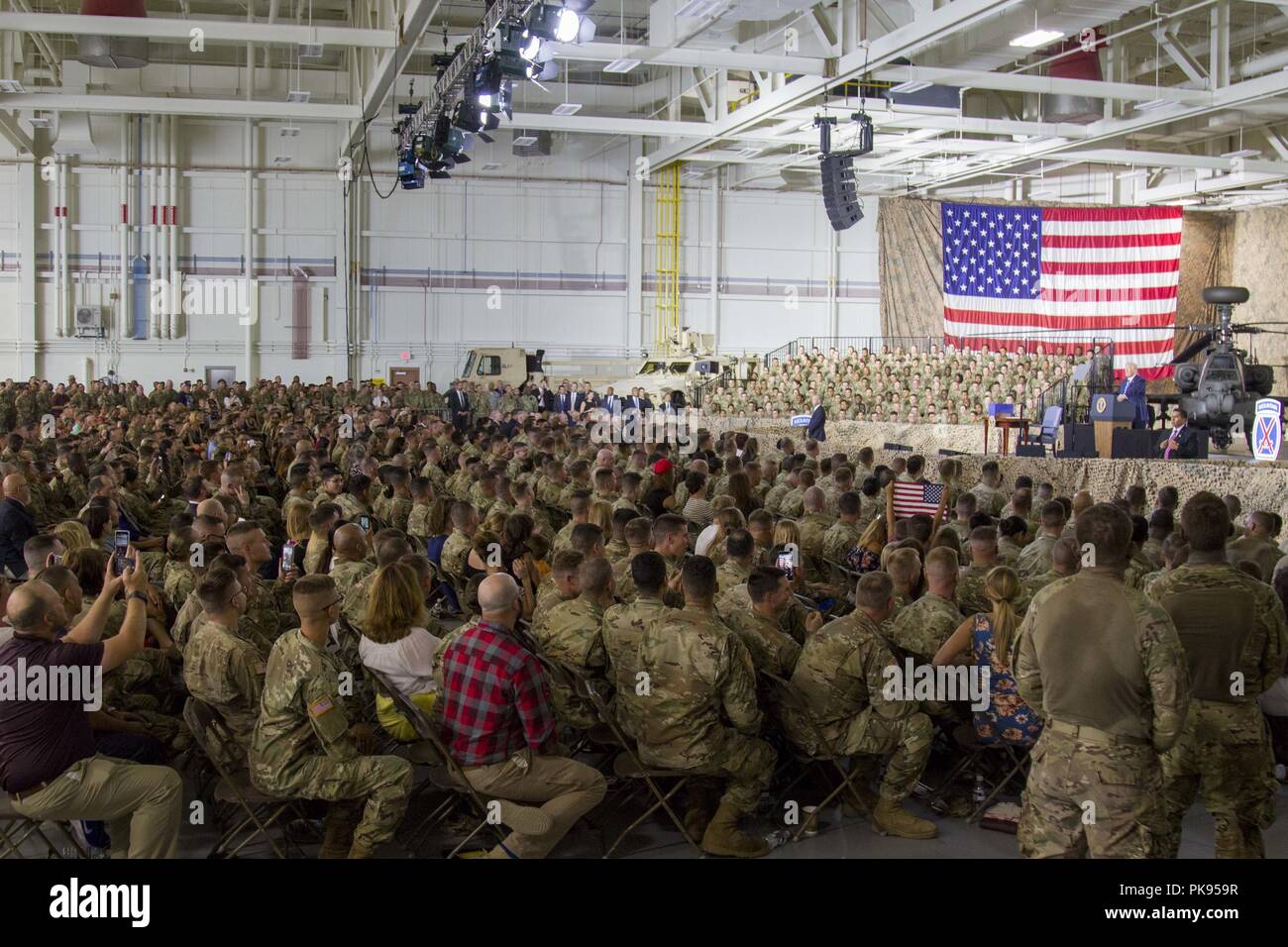 A group of Soldiers and their Families listen to President Donald J. Trump speak during at event at Fort Drum, New York, on August 13, August 13, 2018. President Trump later signed the National Defense Authorization Act of 2019, which recognizes the importance of our military spouses and families by improving hiring practices for childcare services at military childcare centers and assessing the impacts of permanent changes of station on the employment of military spouses. (U.S. Army photo by Sgt. Thomas Scaggs) 180813-A-TZ475-942. () Stock Photo