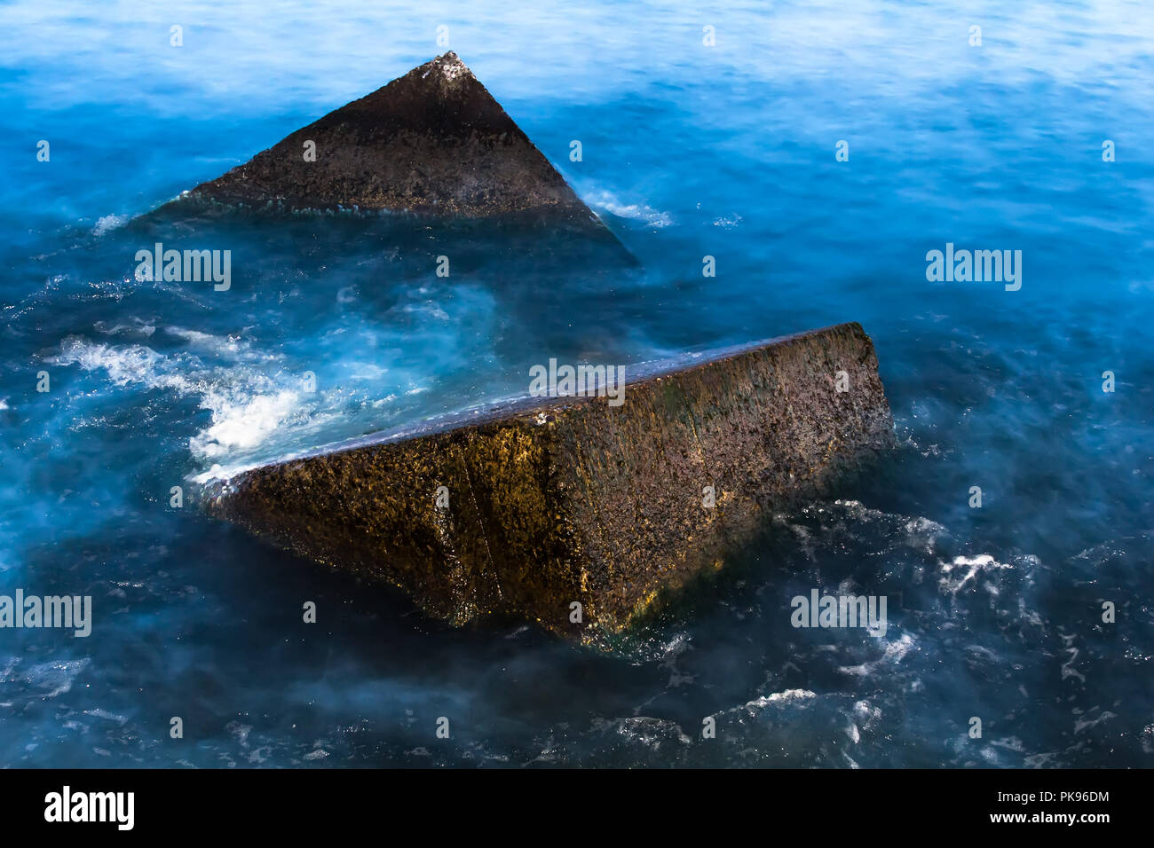 Granite wavebrakers in a Gulf of Riga, Latvia after sunset in August, slow shutter speed Stock Photo