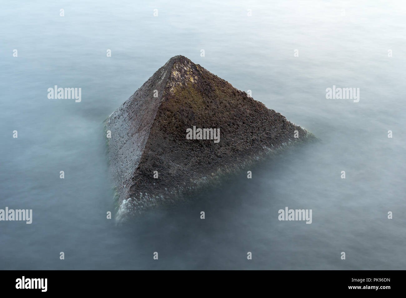 Granite wavebrakers in a Gulf of Riga, Latvia after sunset in August, slow shutter speed Stock Photo