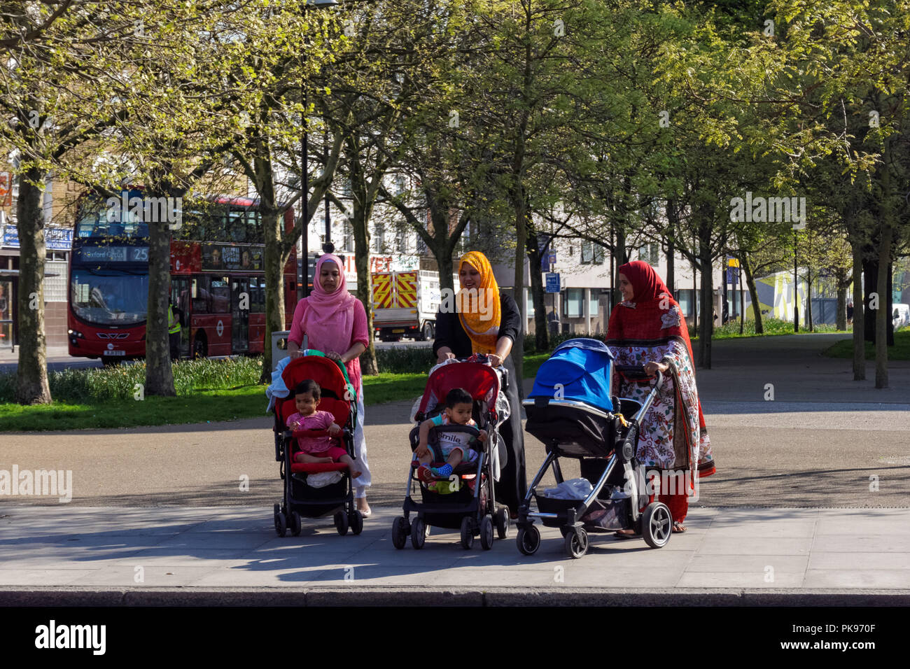 Minority ethnic  women with kids walking in Stepney Green, London England United Kingdom UK Stock Photo