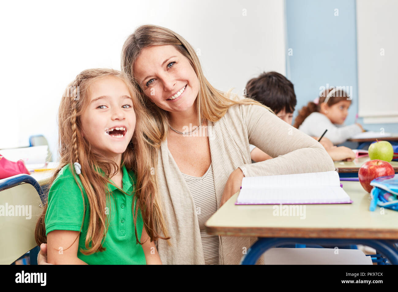 Happy girl as a student with tutoring teacher in elementary school Stock Photo