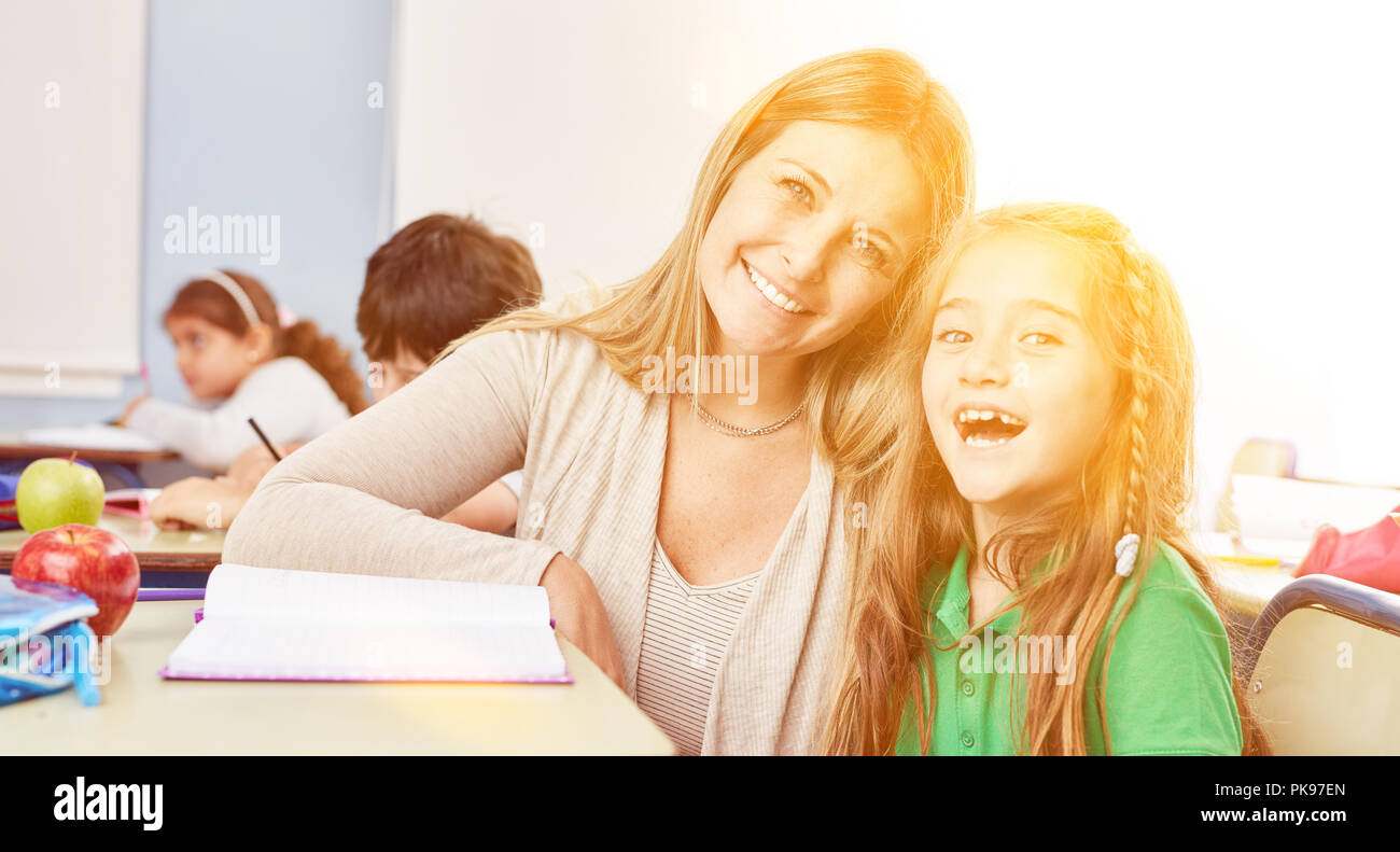 Laughing student gets tutoring lessons from elementary school teacher Stock Photo