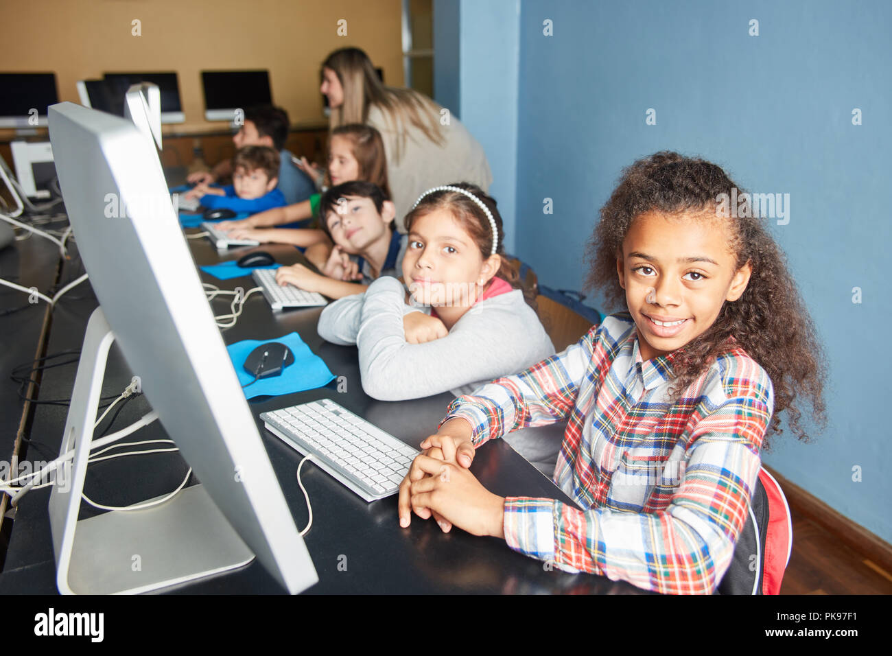 Group of kids learn computer science in a computer class of elementary