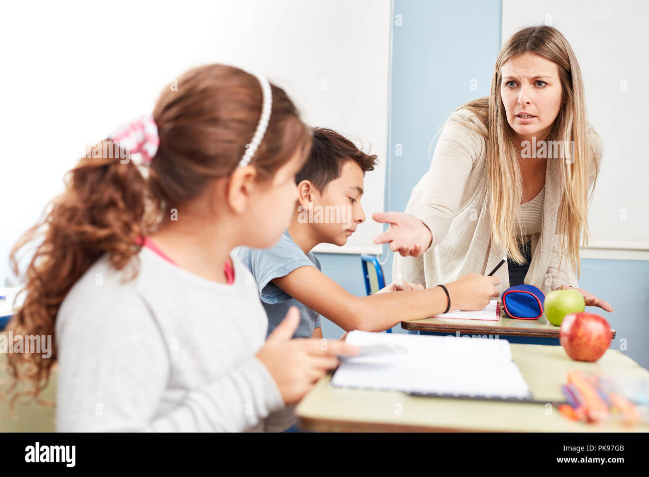 Teacher confiscates a student's mobile phone in class at school Stock Photo