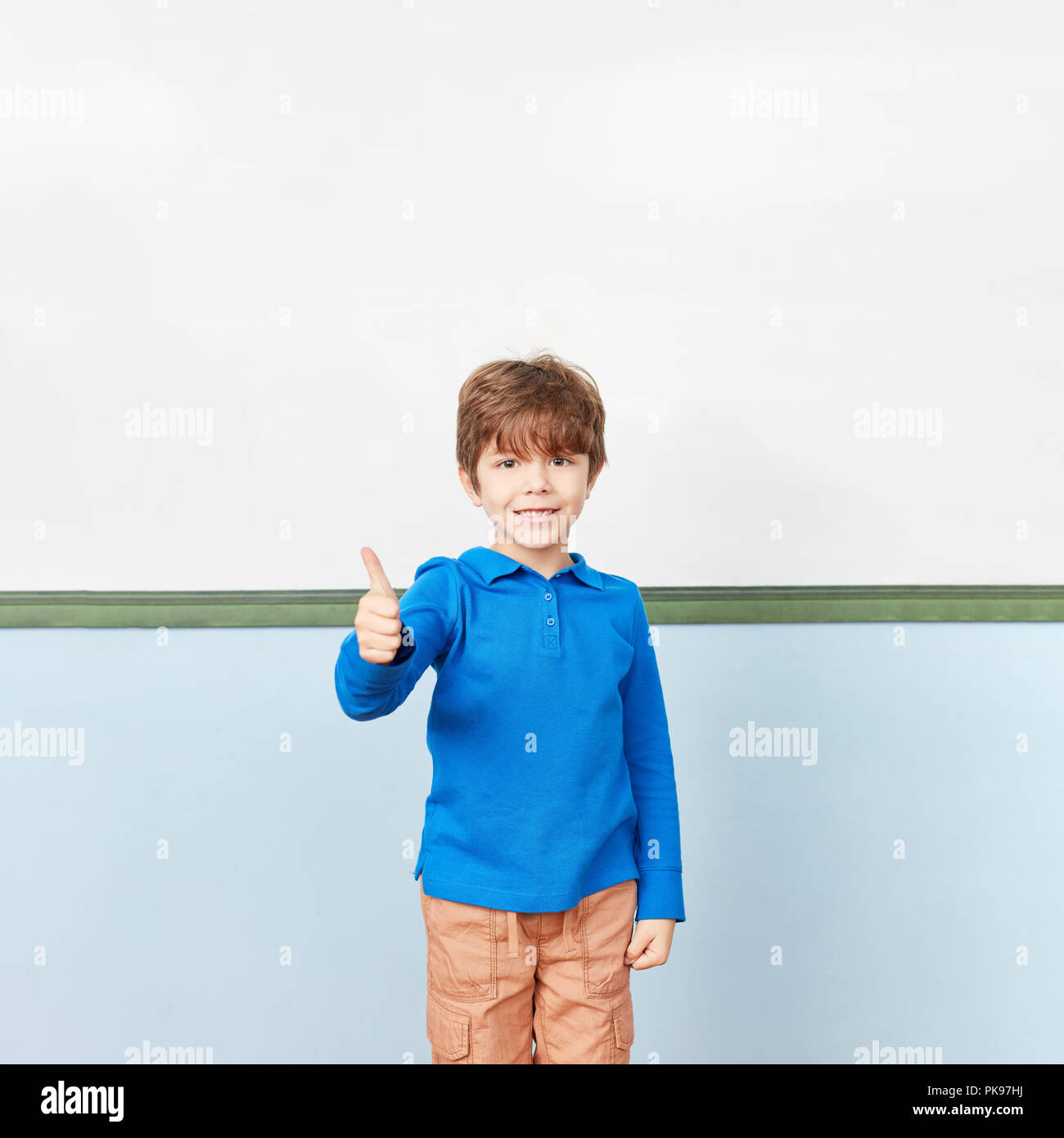 Happy pupil holds thumbs up as best in elementary school Stock Photo ...