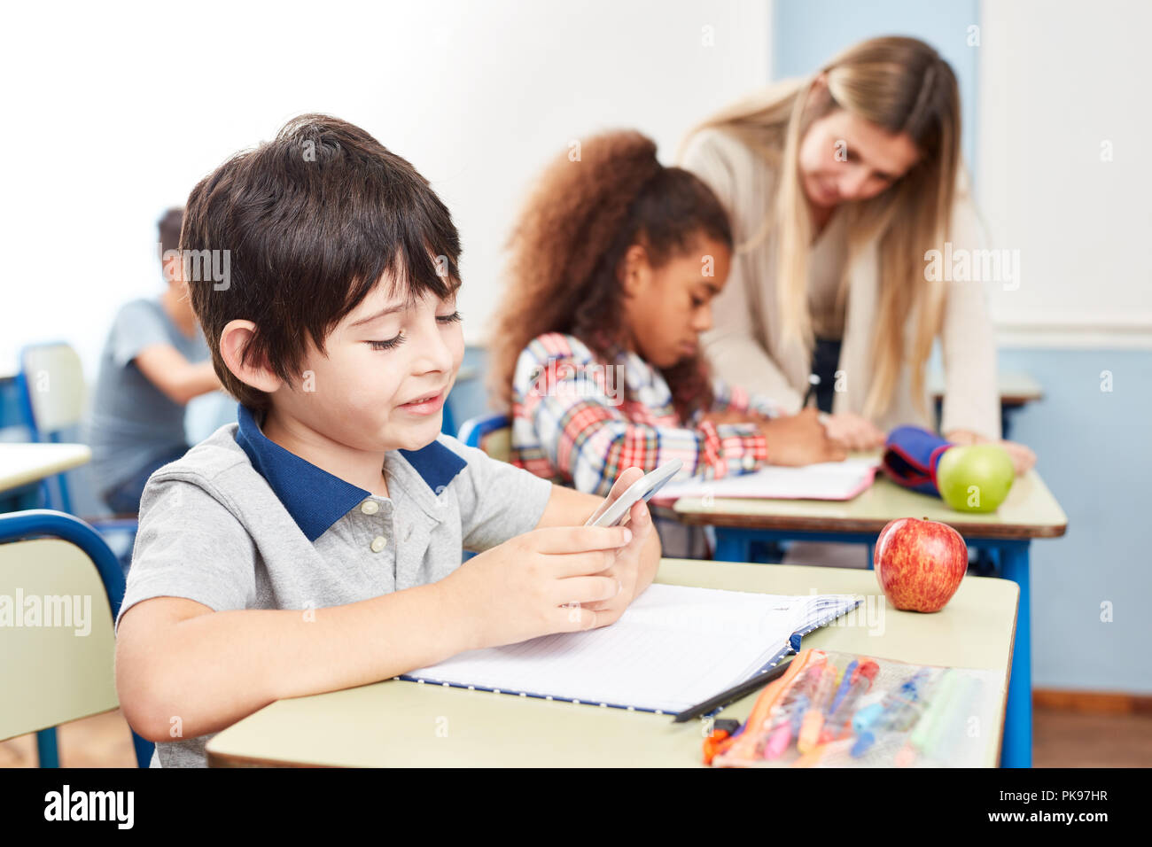 Student reads or writes a text message on the smartphone in class Stock ...