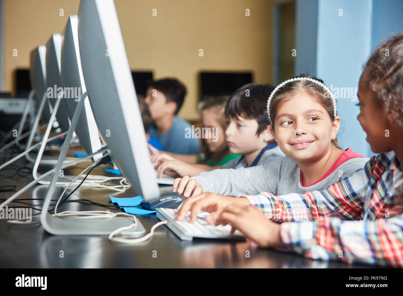 Group of students doing e-learning on the PC in elementary school in computer science course Stock Photo