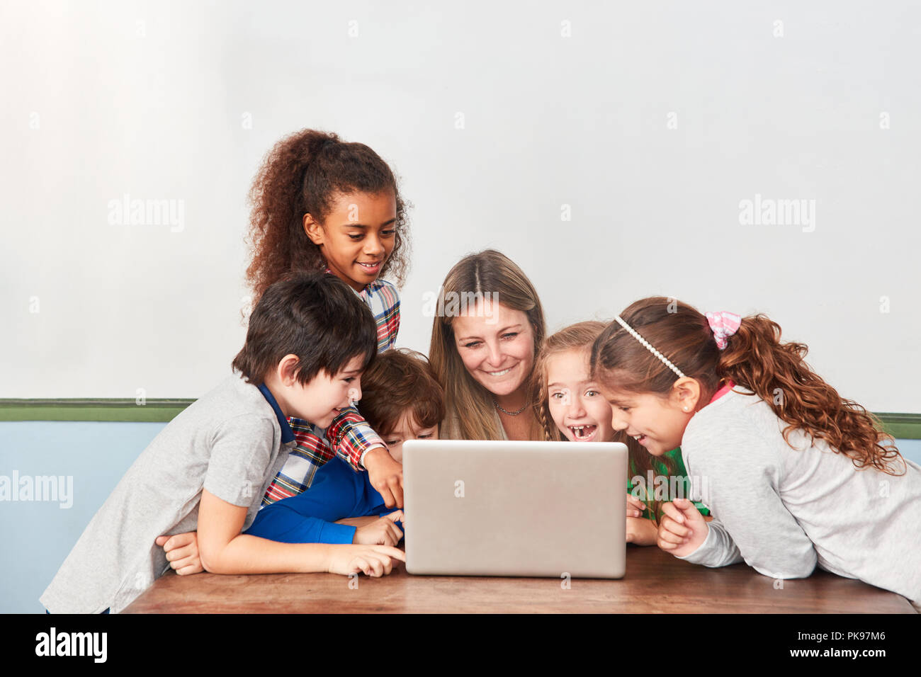 Kids and teacher have fun with the social media in computer lessons Stock Photo