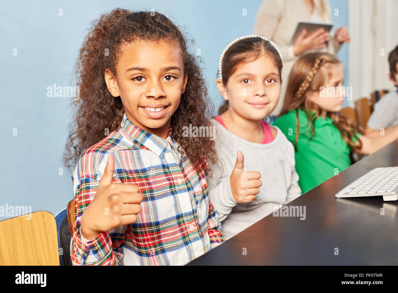 Two girls with thumbs up in the elementary school Stock Photo - Alamy