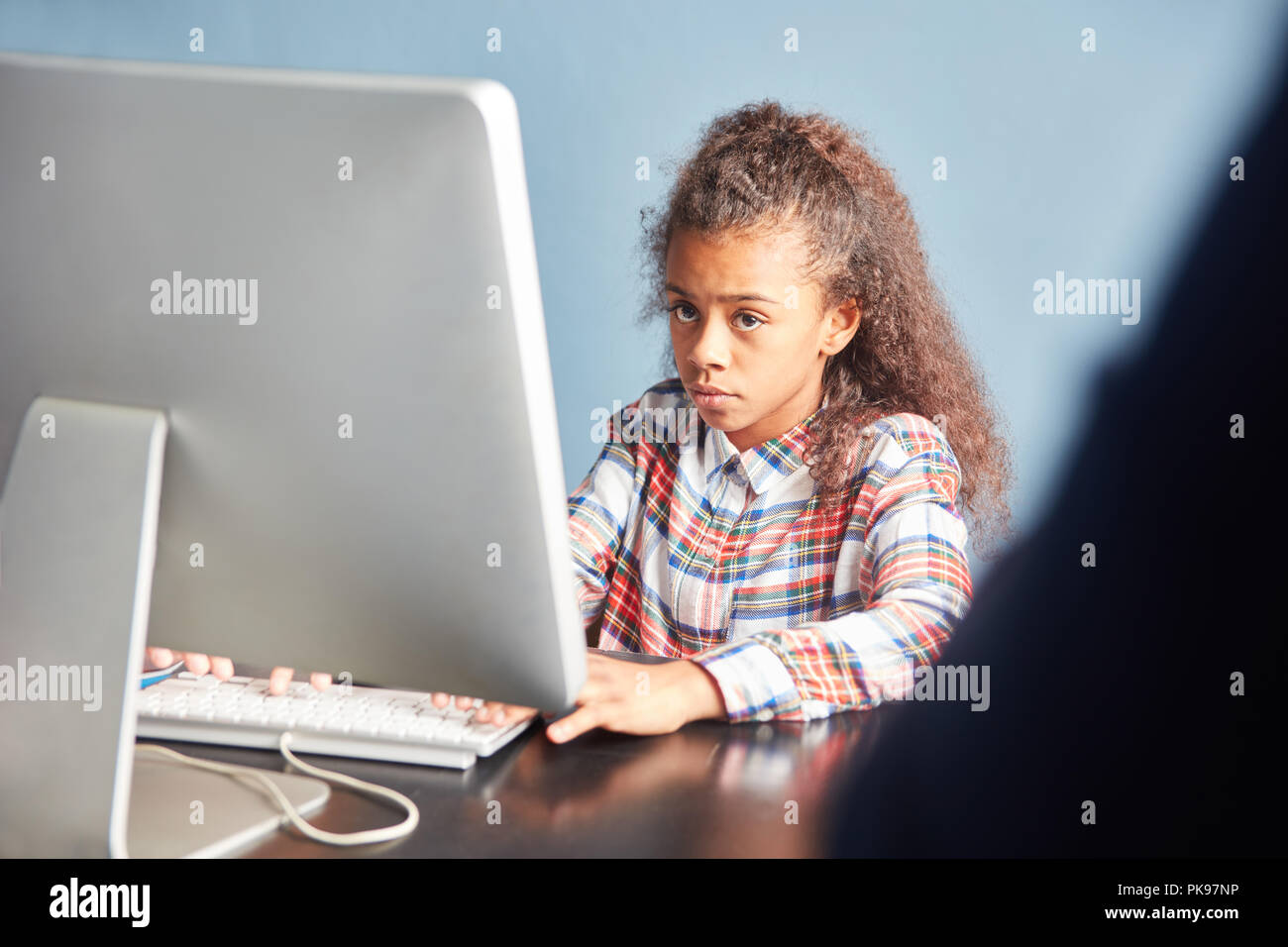 Girl as a student learns at the computer in computer science lessons of the school Stock Photo