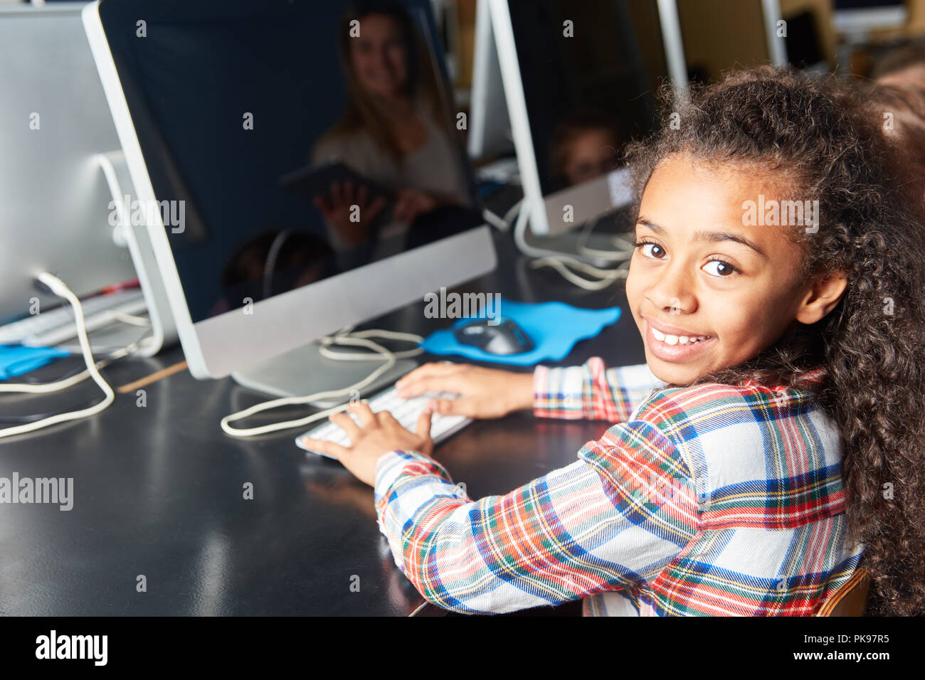 Girl enjoys elementary school computer science course at computer Stock Photo