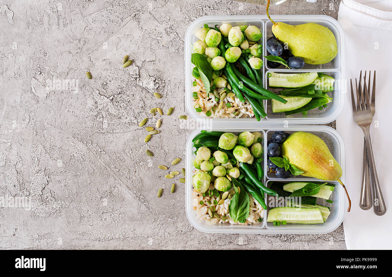 Healthy meal prep containers with chickpeas, chicken, tomatoes, cucumbers  and avocados. Healthy lunch in glass containers on beige rustic background.  Zero waste concept. Selective focus. Stock Photo