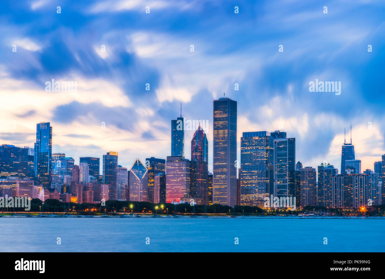 Chicago skyline at sunset with cloudy sky and reflection in water. Stock Photo