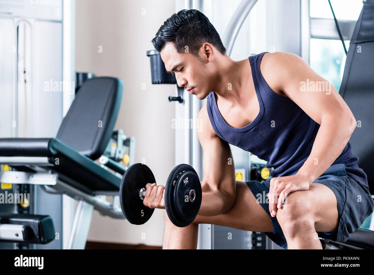 Man lifting dumbbell at gym Stock Photo - Alamy