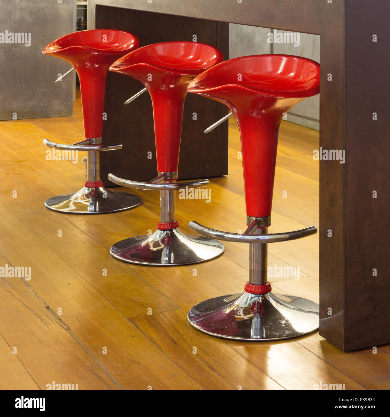 Interior of modern house, counter top with red stools, detail Stock Photo
