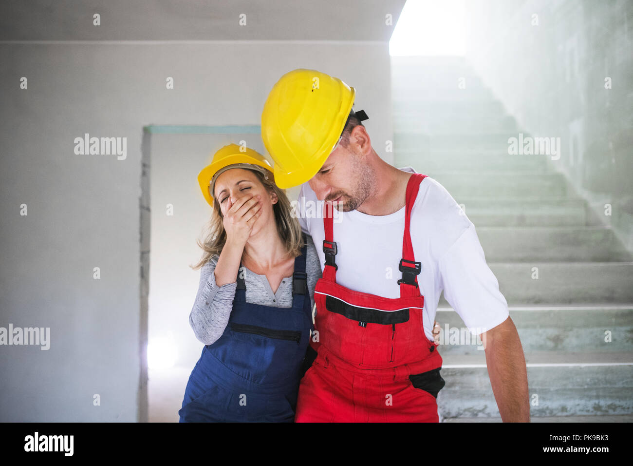 Woman and man workers suffocating at the construction site. Stock Photo