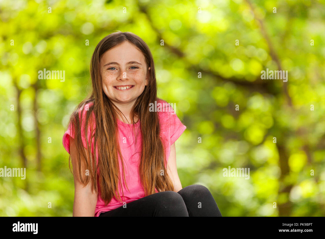 Portrait of smiling girl in the forest Stock Photo - Alamy
