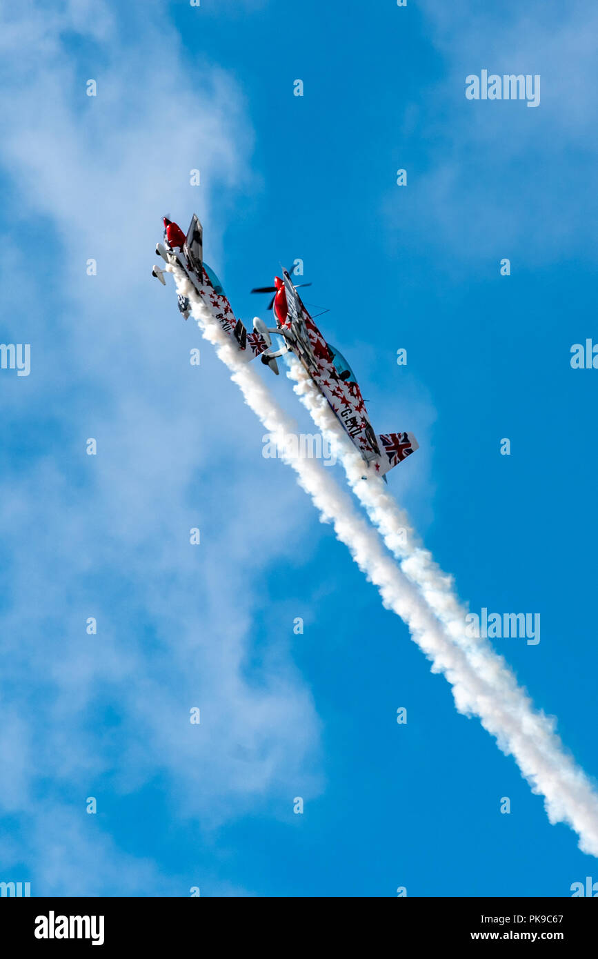 A G-Force Aerobatics Extra 300 and its 40% scale radio-controlled model Extra climb steeply during their coordinated aerobatics display Stock Photo