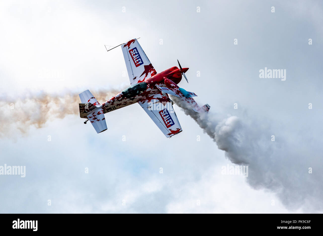A G-Force Aerobatics Extra 300 and 40% radio-controlled scale model Extra cross in mid air during a precision aerobatics display Stock Photo