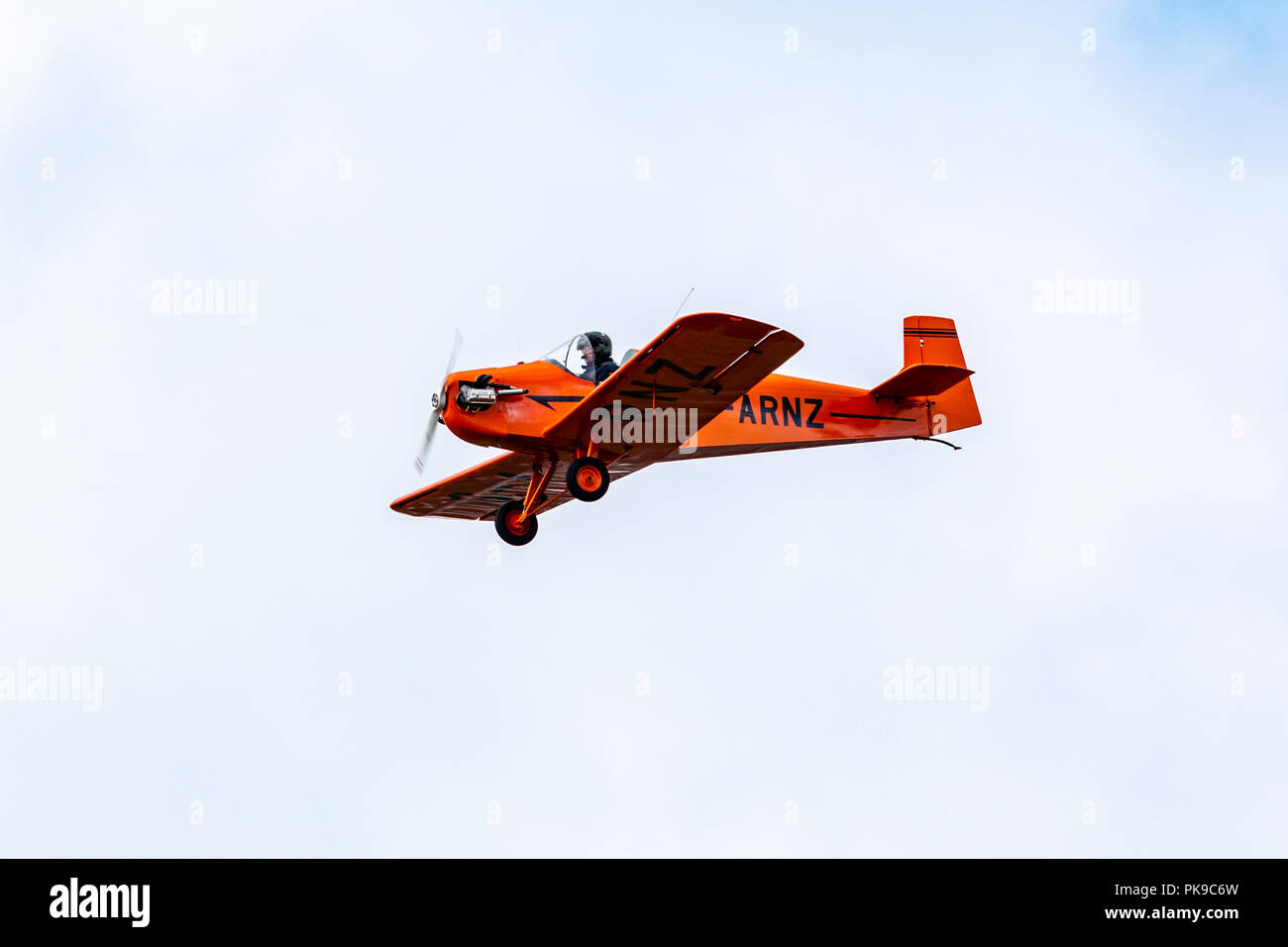 A characterful bright orange Tiger Club D31 Turbulent single seater in level flight during an air display Stock Photo
