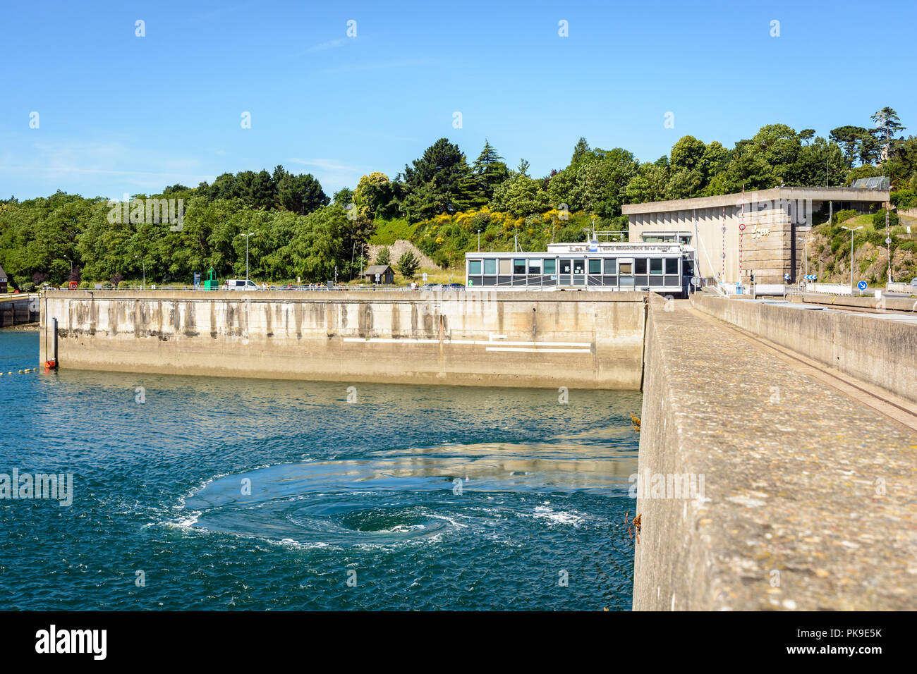 A powerful whirlpool generated at the surface of the water by a turbine of the Rance tidal power station near Saint-Malo in Brittany, France. Stock Photo