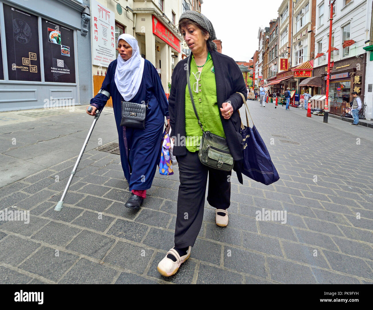 Two women in Gerrard Street, Chinatown, London, England, UK. Stock Photo