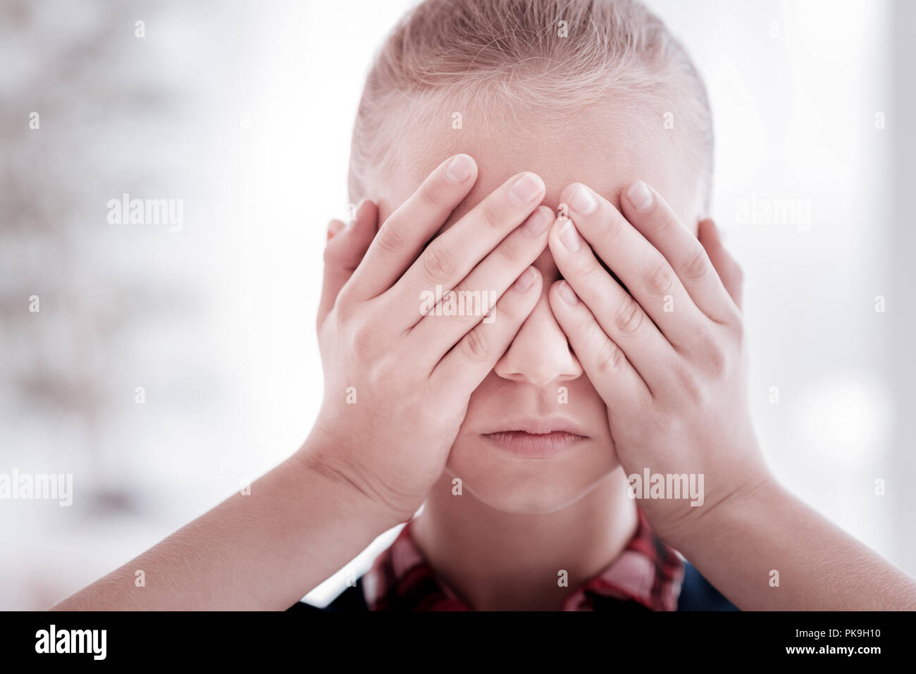 Teenage girl closing her eyes while hiding from the problems Stock Photo