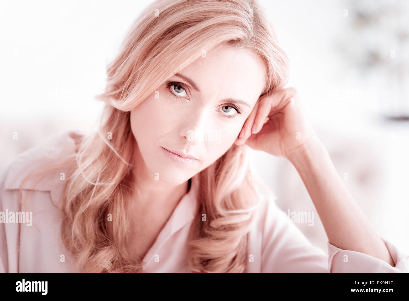 Tired young woman feeling unhappy and putting her head on her hand Stock Photo