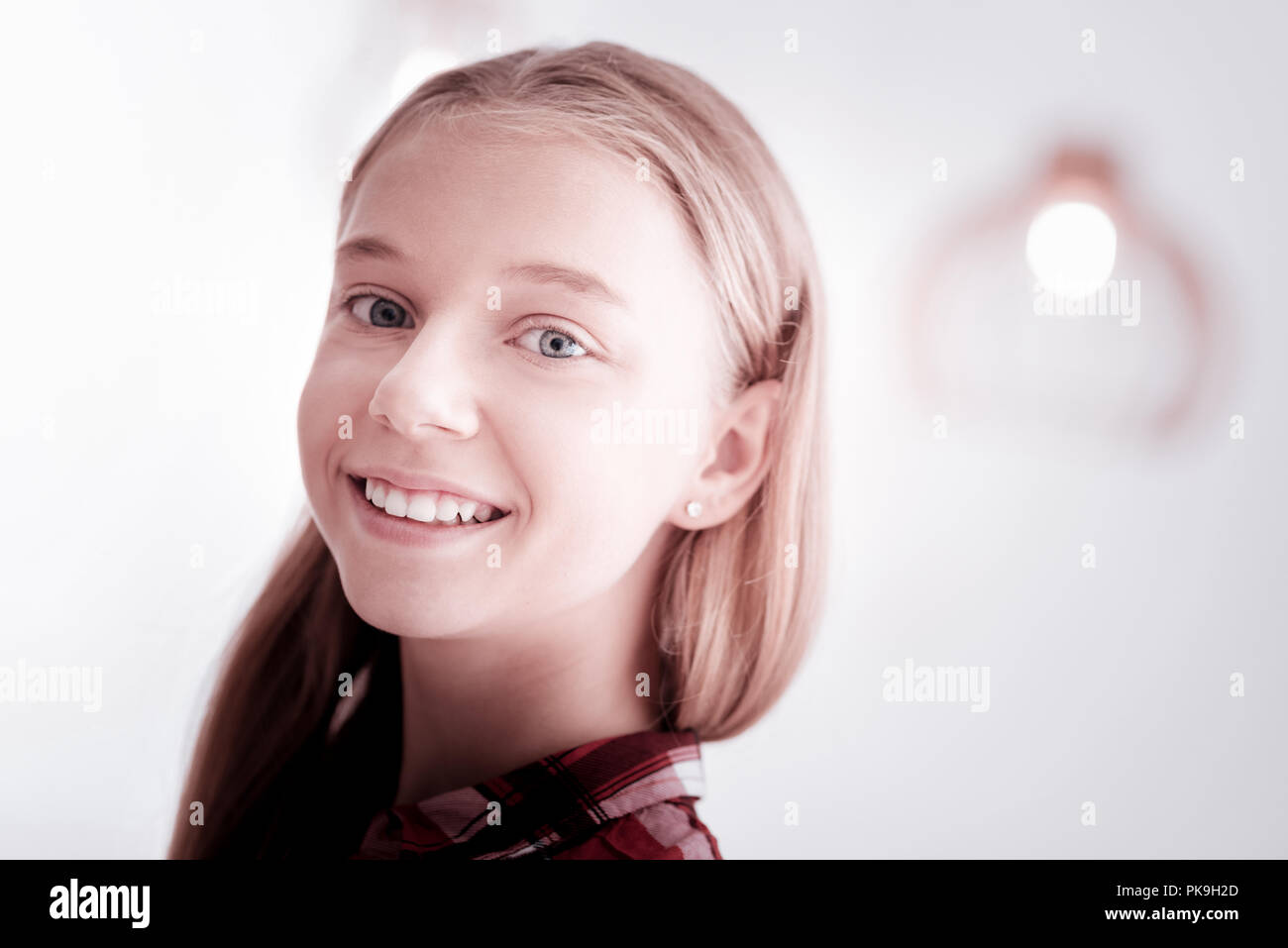 Lovely teenage girl being in a wonderful mood and smiling happily Stock Photo