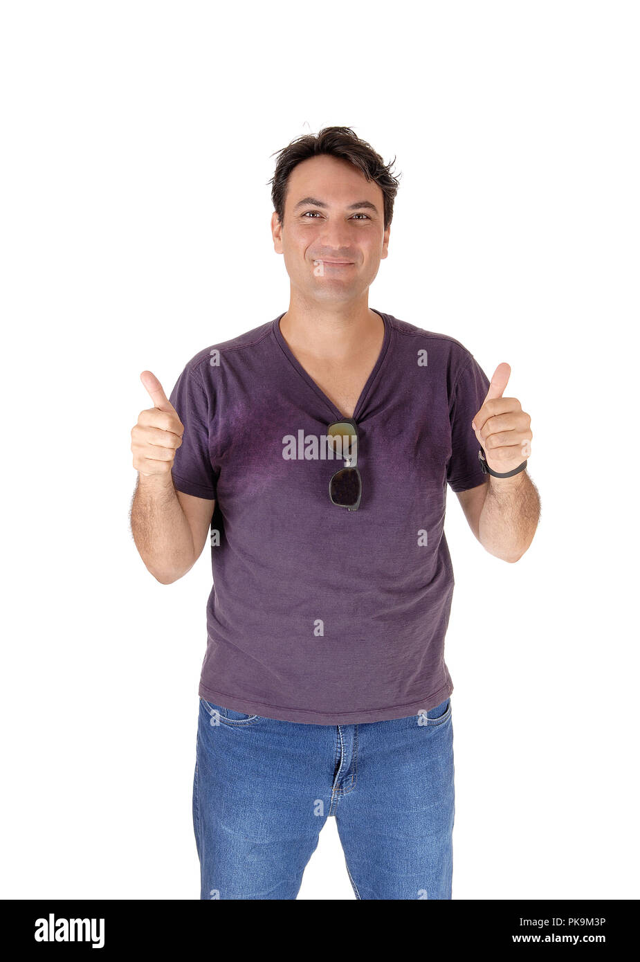 A smiling young Caucasian man standing in a burgundy shirt and  sunglasses, holding two thumps up, isolated for white background Stock Photo